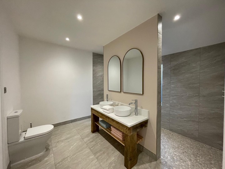 Double vanity on a rustic timber washstand with arched mirrors
