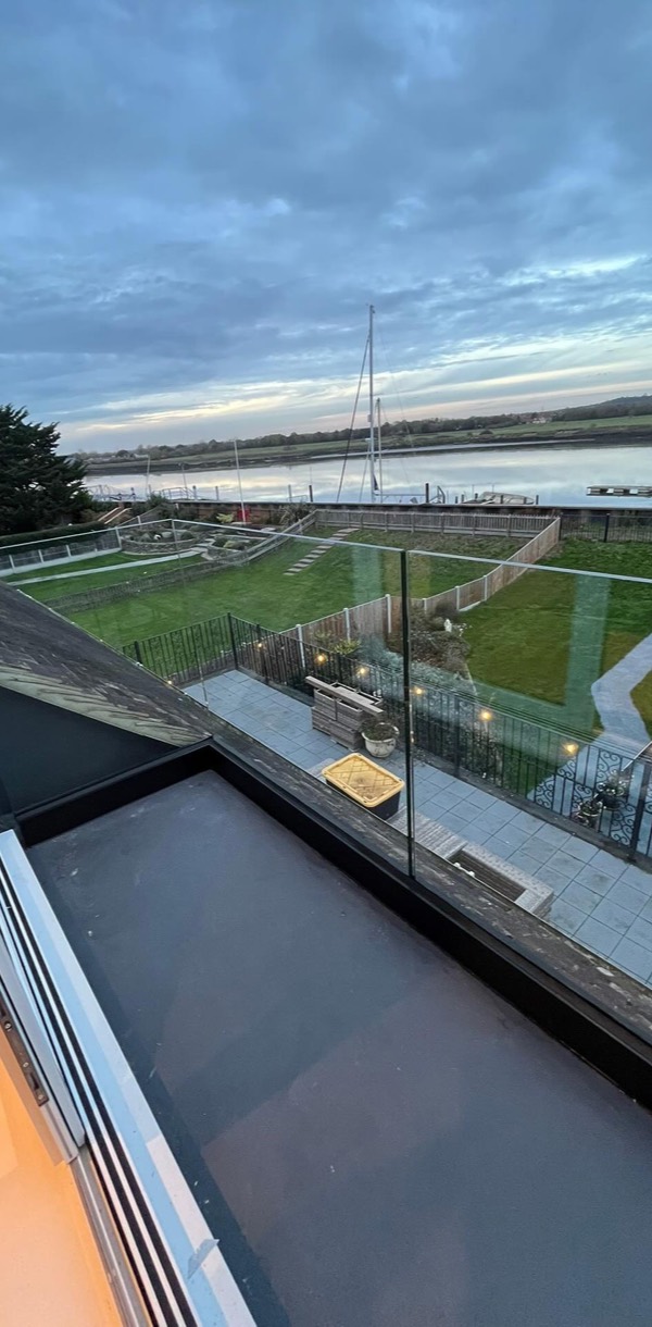 Balcony with a glass balustrade looking over the river at dusk