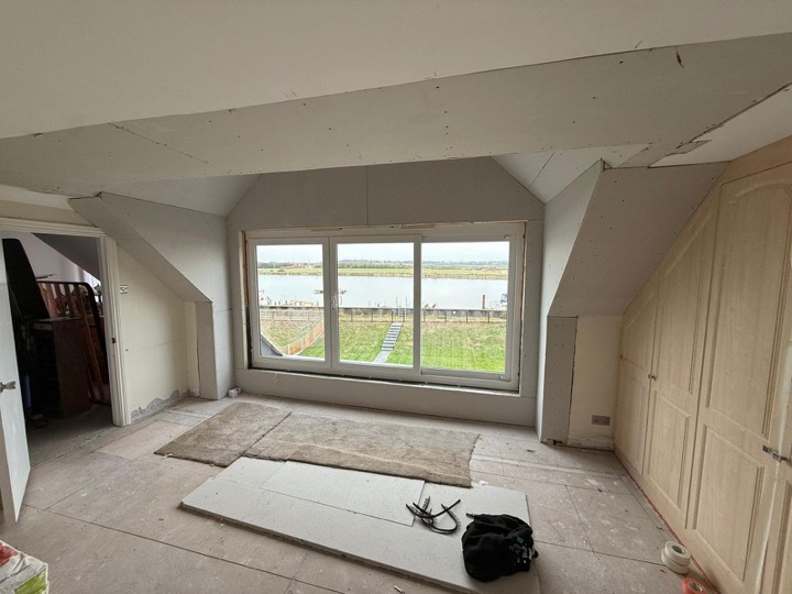 Room in the roof with a wide window looking over the water